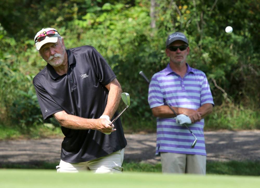 Bruce North pitches a ball on the 15th hole while Darren Graves looks on during Tamarack masters men’s quarterfinals at Clear Lake Golf Course on Wednesday. (Photos by Thomas Friesen/The Brandon Sun)