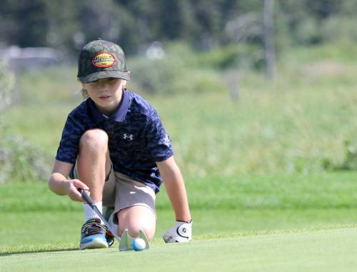 Bo Calvert, 7, lines up a putt on the seventh green. (Thomas Friesen/The 
Brandon Sun)