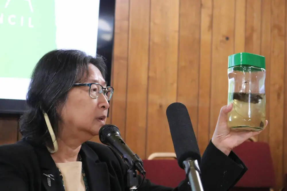 Madeline Luke, ag committee volunteer for Dakota Resource Council, holds a jar containing cattle waste and water that she mixed to represent potential contamination from large-scale dairy operations during a rally in Bismarck, N.D. Thursday. (Jenny Schlect/Agweek)