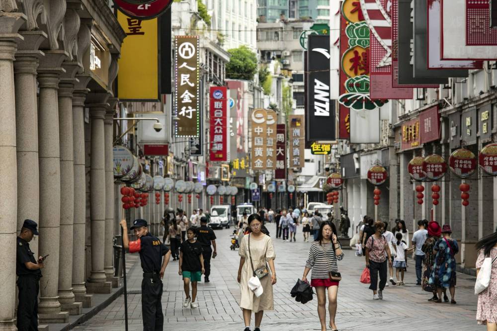 Pedestrians pass stores in Guangzhou, China. Chinese state media regularly amplify Canadian grievances against the U.S. while portraying China as a reliable economic partner, writes Stephen Nagy. (Qilai Shen/Bloomberg)