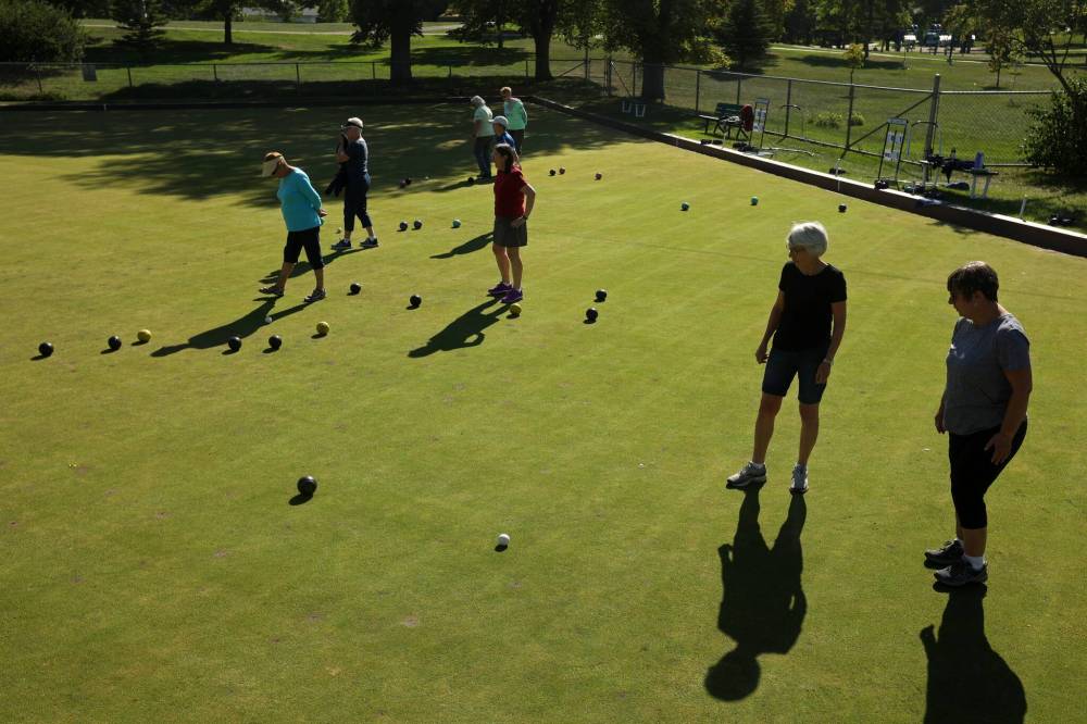 Gay Mayberry and Therese Alexander (bottom right) watch a bowl during a match. (Tim Smith/The Brandon Sun)