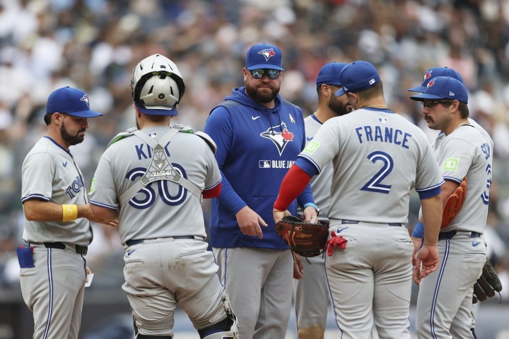 Toronto Blue Jays manager John Schneider, centre, stands on the mound after pulling Max Scherzer during the fifth inning of a baseball game against the New York Yankees, Sunday, Sept. 7, 2025, in New York. (AP Photo/Heather Khalifa)