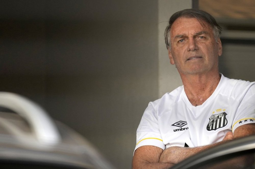 Brazil's former President Jair Bolsonaro stands at the entrance to his home where he is under house arrest in Brasilia, Brazil, Friday, Aug. 29, 2025. (AP Photo/Eraldo Peres)