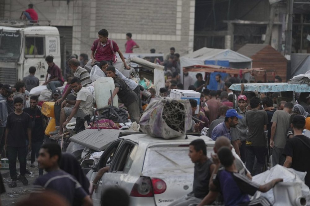 Displaced Palestinians fleeing Jabaliya move with their belongings on a street in Gaza City, Tuesday, Aug. 26, 2025. (AP Photo/Jehad Alshrafi)