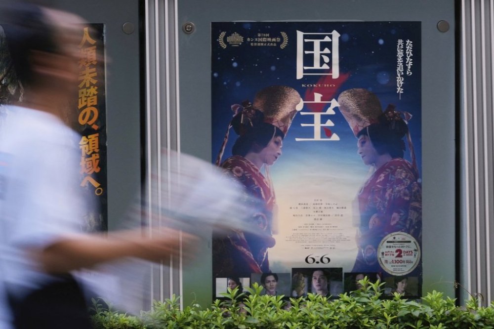 A person walks by a poster of film