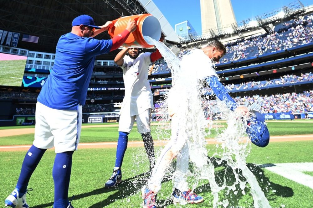 Toronto Blue Jays centre-fielder Myles Straw (3) is doused with ice water by teammates Alejandro Kirk, left, and Vladimir Guerrero Jr. after they defeated the Milwaukee Brewers in MLB baseball action in Toronto on Sunday, Aug. 31, 2025. THE CANADIAN PRESS/Jon Blacker