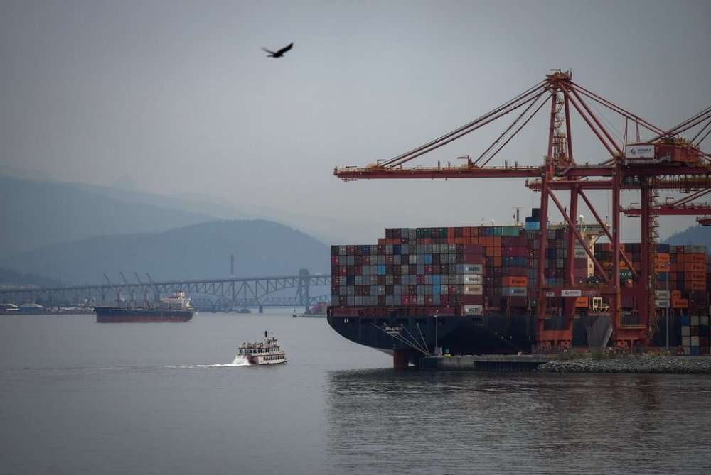 The paddle wheeler Constitution passes the container ship GSL Lydia docked at port, while sailing on the harbour as wildfire smoke hangs in the air, in Vancouver, on Thursday, Aug. 28, 2025. THE CANADIAN PRESS/Darryl Dyck
