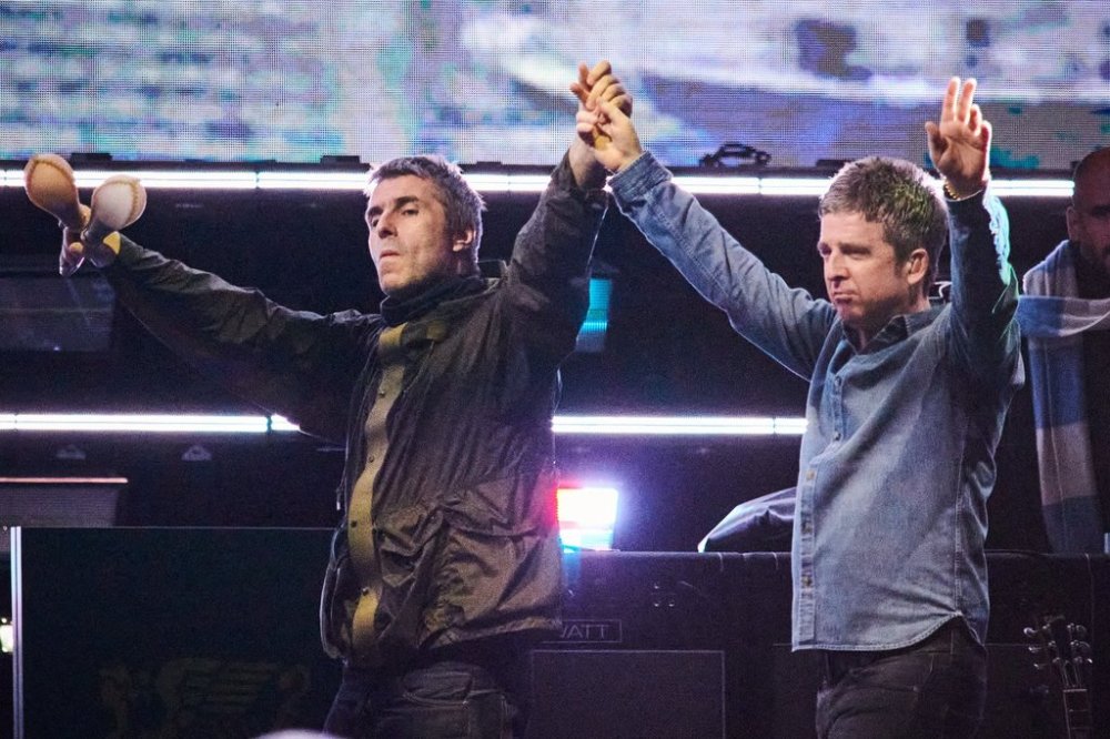Liam Gallagher (left) and Noel Gallagher of Oasis walk onstage together during their reunion tour in Toronto, on Sunday, Aug. 24, 2025. THE CANADIAN PRESS/Sammy Kogan
