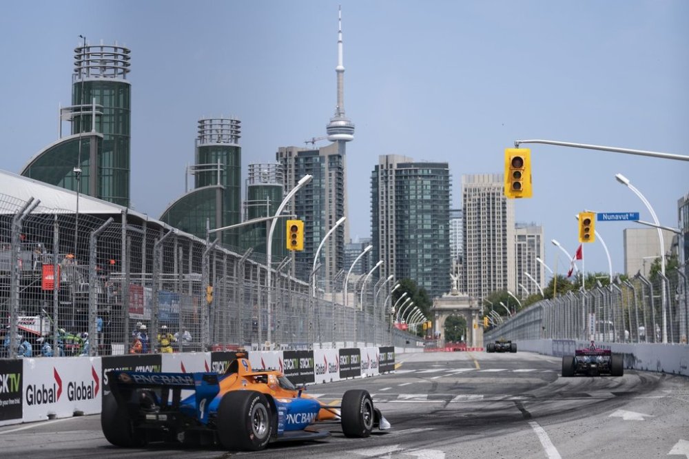 Third place finisher Scott Dixon (9) of New Zealand, left, trails second place finisher Kyle Kirkwood (27) of the United States and winner Colton Herta (26) of the United States during the 2024 Ontario Honda Dealers Indy, in Toronto on Sunday, July 21, 2024. THE CANADIAN PRESS/Arlyn McAdorey