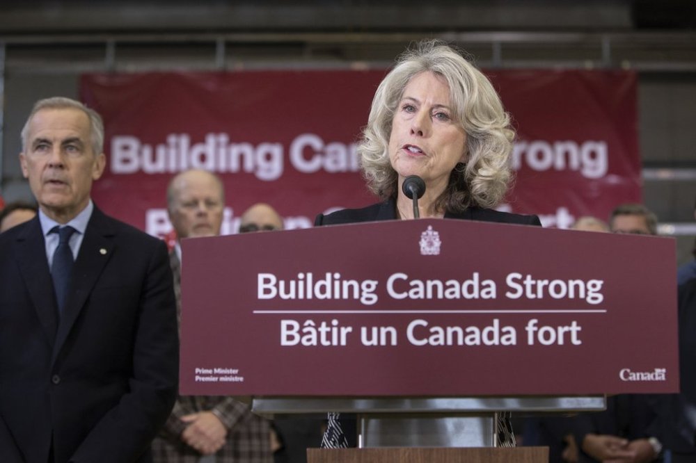 The head of the new federal government Major Projects Office Dawn Farrell speaks, as Prime Minister Mark Carney, looks on, during the announcement of five major projects in Edmonton on Thursday, Sept. 11, 2025. THE CANADIAN PRESS/Amber Bracken