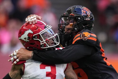 Calgary Stampeders quarterback Vernon Adams Jr., left, is hit by B.C. Lions' Bradlee Anae after releasing the ball during the first half of a CFL football game, in Vancouver, on Saturday, Oct. 4, 2025. THE CANADIAN PRESS/Darryl Dyck