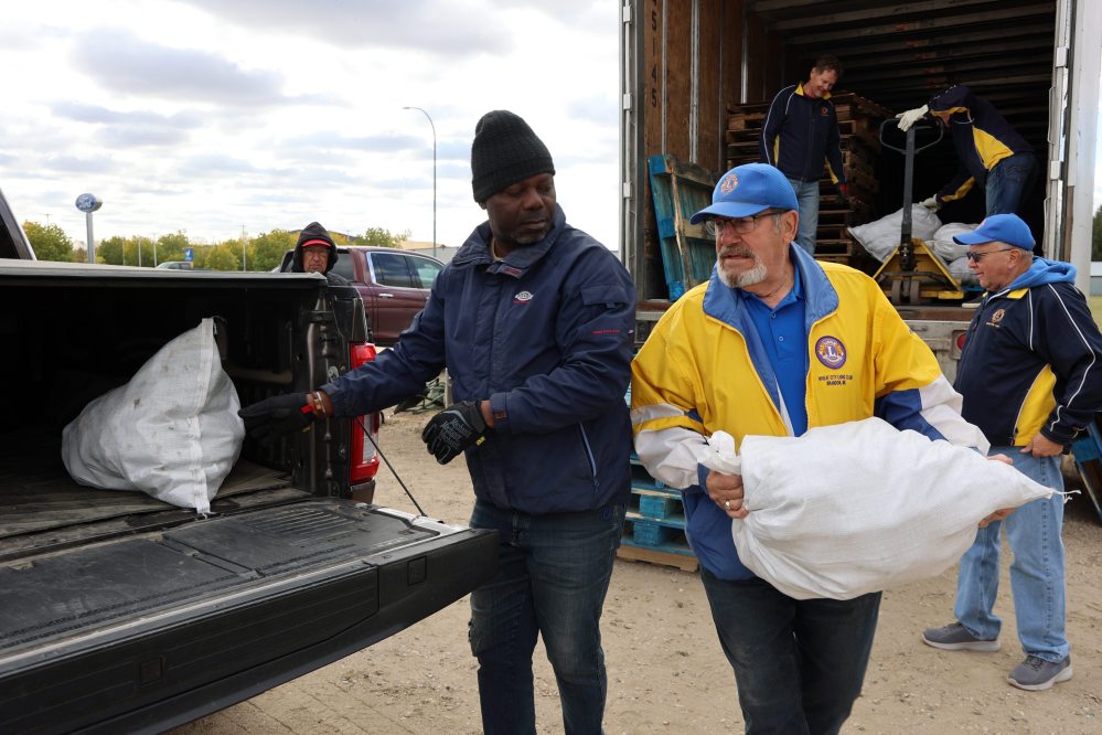 Terry Gunnlaugson (right), a member Wheat City Lions Club, heaves a bag of potatoes into the back of a pickup truck during last year's annual potato sale. It will once again be held in an empty parking lot on 18th Street on Brandon’s North Hill, directly across from the Kelleher Ford dealership. (Connor McDowell/The Brandon Sun files)