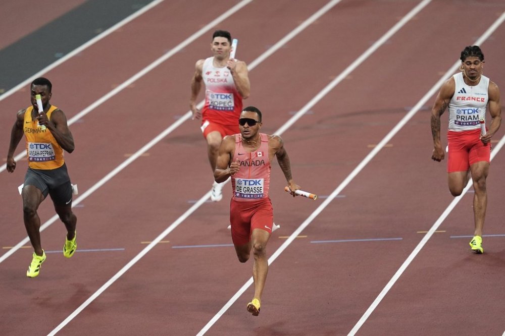 Canada's Andre De Grasse competes with Germany's Lucas Ansah-Peprah, Poland's Dominik Kopec and France's Aymeric Priam in a men's 4 X 100 meters relay heat at the World Athletics Championships in Tokyo, Saturday, Sept. 20, 2025. (AP Photo/Abbie Parr)