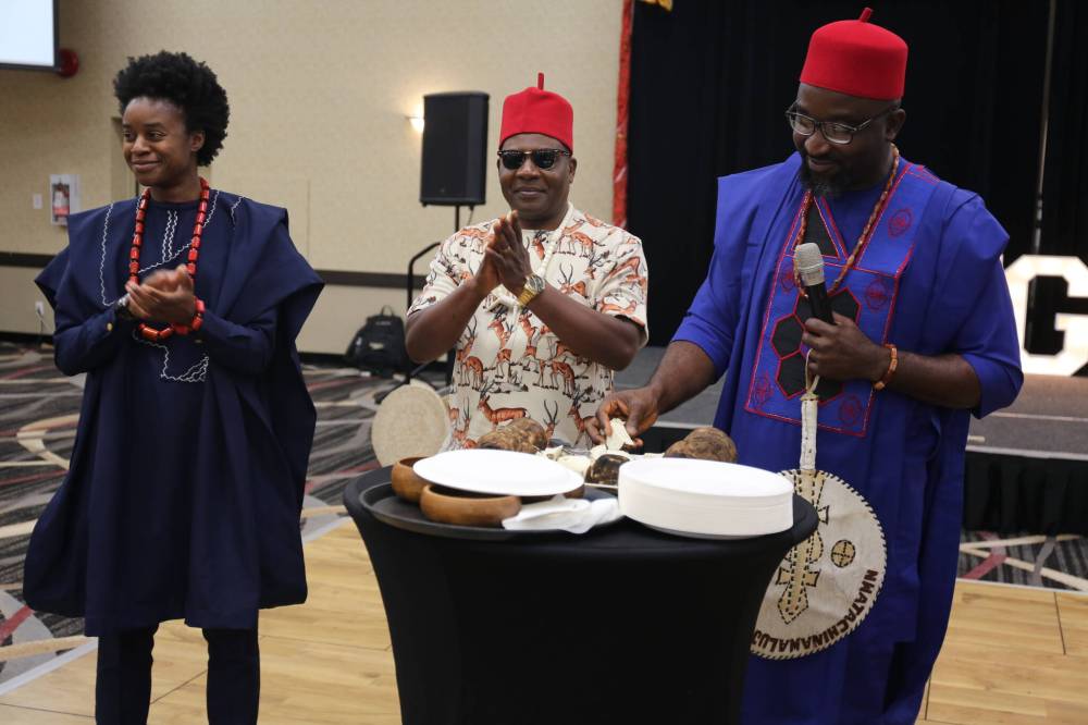 Umunna Igbo Cultural Association of Manitoba vice-president Ifeanyi Chidume (right) takes a yam from a plate, while Manitoba Deputy Premier Uzoma Asagwara (left) and Umunna Igbo Cultural Association of Manitoba public relations officer Ejike Nwankwo look on during the New Yam Festival on Saturday at the Victoria Inn. (Abiola Odutola/The Brandon Sun)