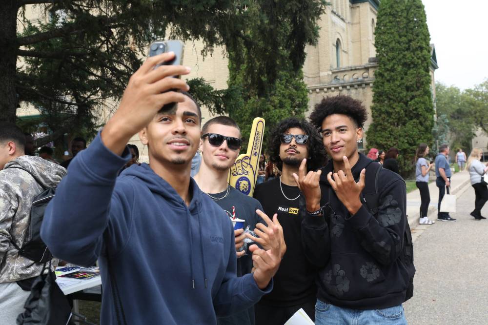 New Brandon University students Isaac Brown, Nick Hudyma, Munroop Gill and Malik Brown take a selfie in front of the Brandon University Student Union's stand during the orientation program on Tuesday afternoon. (Abiola Odutola/The Brandon Sun)