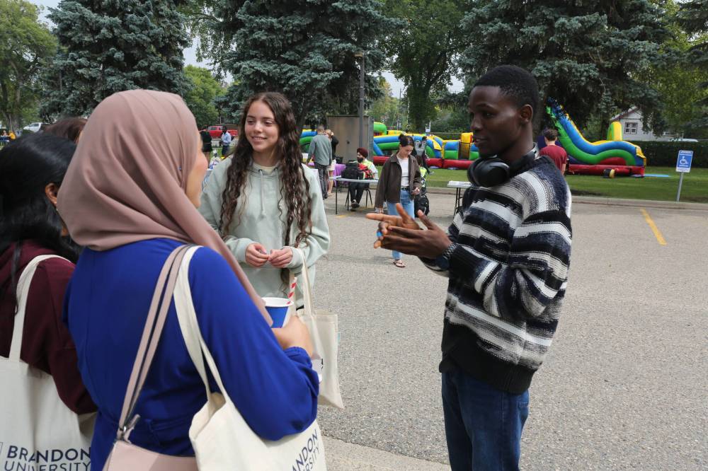 BU international student representative Tosin Salau talks to new students by the Brandon University Student Union's stand during the orientation program on Tuesday afternoon. (Abiola Odutola/The Brandon Sun)