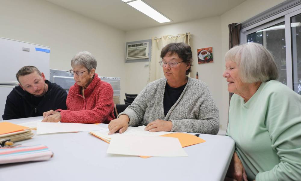 Spruce Woods Housing Co-op employee Sean Dyck (from left), board president Noreen Mitchell, manager Eva Cameron and board vice-president Maxine Montague go over minutes from the first Spruce Woods Housing Co-op meetings on Thursday. (Alex Lambert/The Brandon Sun)