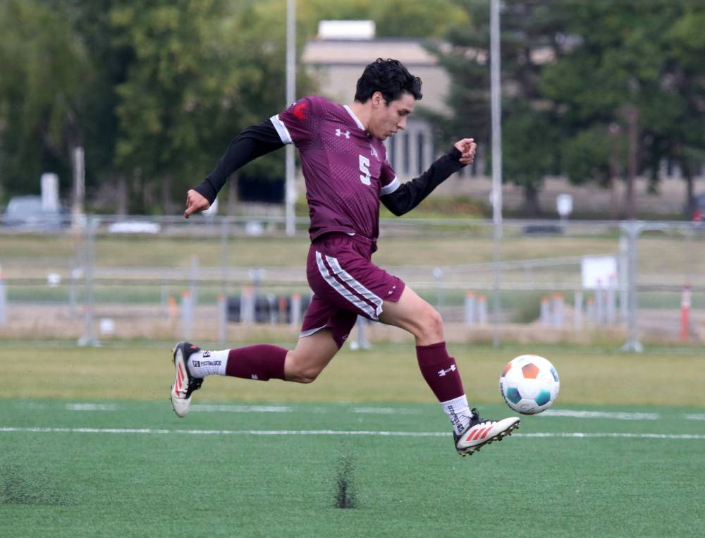 Assiniboine College Cougars Kevin Cruz jumps to control the ball against the Canadian Mennonite University Blazers during their MCAC men's soccer season opener at Cougars Field on Saturday. (Thomas Friesen/The Brandon Sun)
