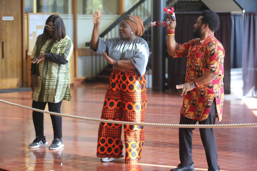 Olaide Adewuyi (middle) leads the Nigerian dancers Efemena Esosuakpo (left) and Emmanuel Akobi as the team dances to Nigerian music at city hall on Tuesday. (Abiola Odutola/The Brandon Sun)