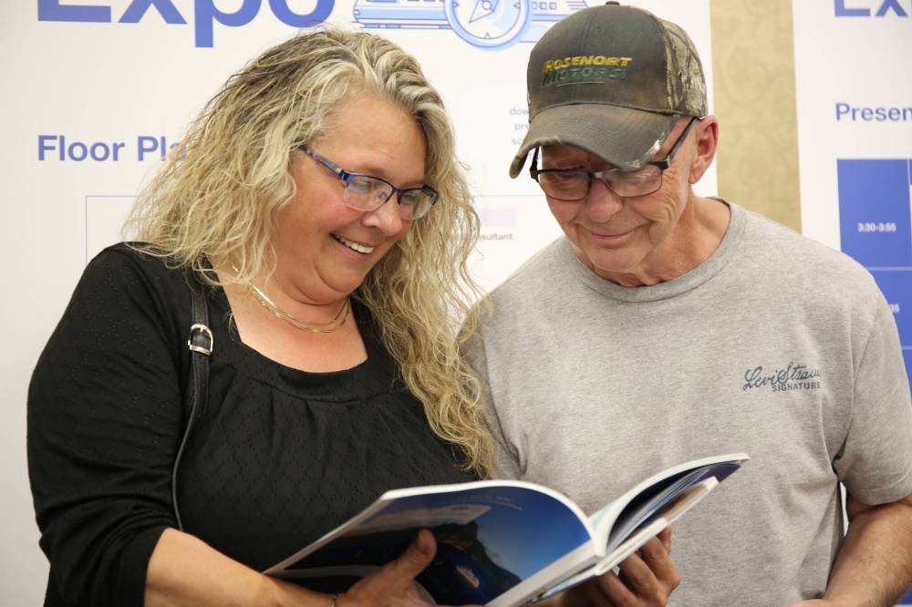 Sandy Opruk and husband Neil McLaughlin, from Minnedosa, look over a travel brochure about river cruises during CAA Manitoba's Travel Expo Tuesday afternoon at the Victoria Inn in Brandon. (Michele McDougall/The Brandon Sun)
