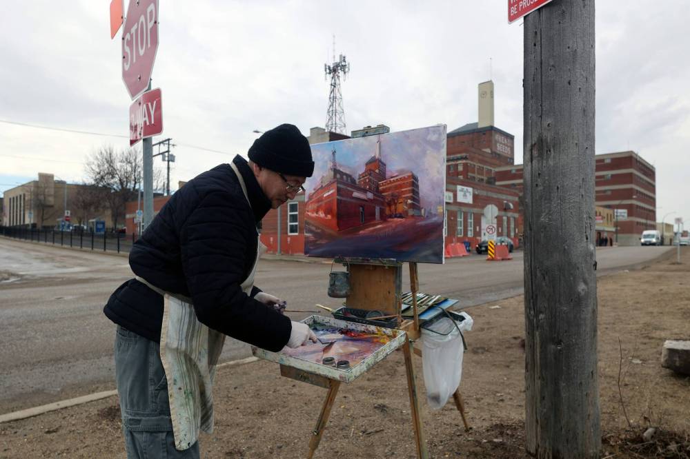 Weiming Zhao paints a downtown cityscape in Brandon earlier this year. Beginning Sept. 19, Brandon’s Section 6 Brewing Company will host an exhibit featuring 60 of Zhao’s pieces celebrating downtown Brandon’s historic buildings. (Connor McDowell/The Brandon Sun files)