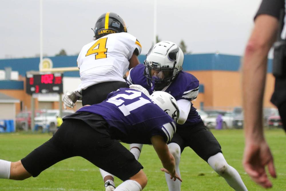 Dakota Lancers receiver Darius Sapong-Rean splits Vincent Massey Vikings defenders Amadeus Crossman (21) and Corwyn McClean during their Winnipeg High School Football League game at Doug Steeves Field on Thursday. (Thomas Friesen/The Brandon Sun)