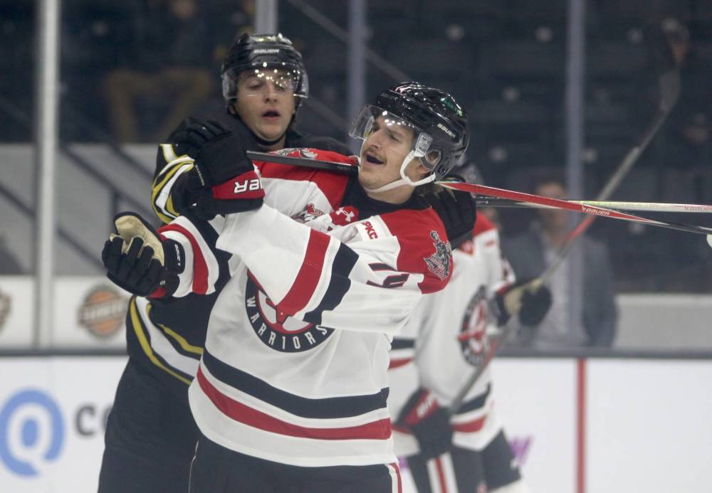 Grayson Burzynski of the Brandon Wheat Kings gets his stick on Moose Jaw’s Ethan Semeniuk’s neck after the whistle as the Warriors alternate captain appeals to a referee during their Western Hockey League season opener at Assiniboine Credit Union Place on Friday. (Thomas Friesen/The Brandon Sun)