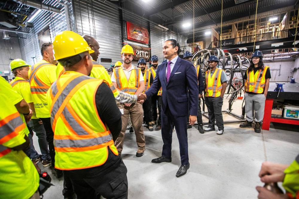 Premier Wab Kinew shakes hands with union members at a press conference in Winnipeg on Tuesday. (Mikaela MacKenzie/Winnipeg Free Press)