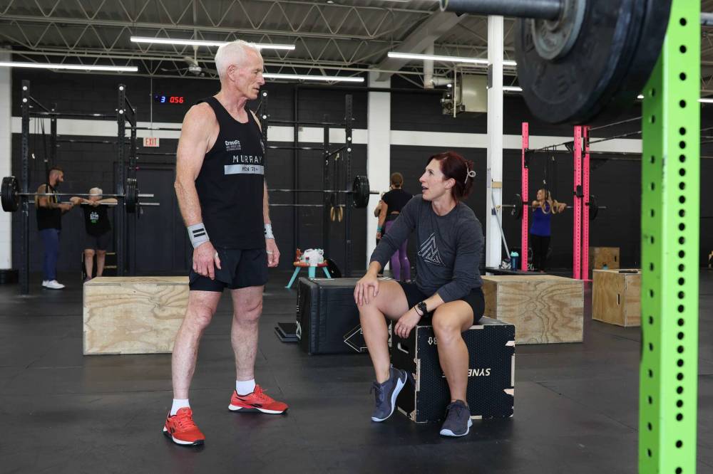 Murray chats with his coach, Jenn McMillan, co-owner of Rocked Community Fitness, while training at the gym in Brandon on Tuesday.
