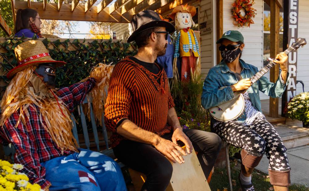 Blake Hamilton (left) and Abby Reuben play the drums and banjo in front of the Antlers and Oak Diner scarecrow display during Souris Scarecrow Days in 2021. Scarecrow Days returns to Souris Sept. 26–28. (The Brandon Sun files)