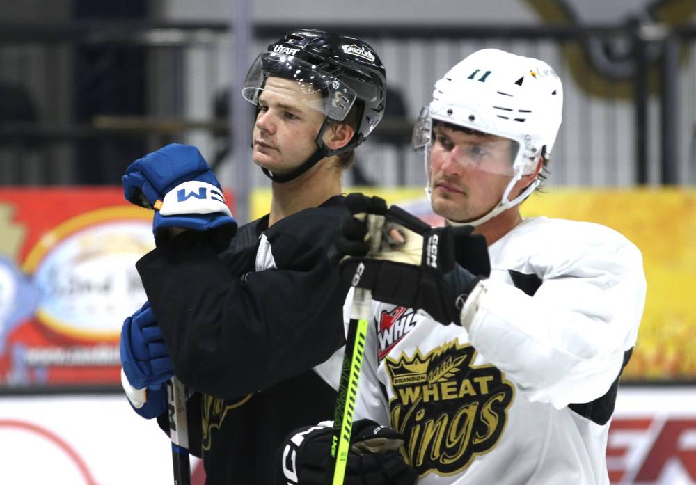 Briley Wood, left, listens to the explanation for a drill during a Brandon Wheat Kings practice on Monday with his friend Lynden McCallum, right. He played his rookie professional season last winter the ECHL’s Utah Grizzlies. (Perry Bergson/The Brandon Sun)