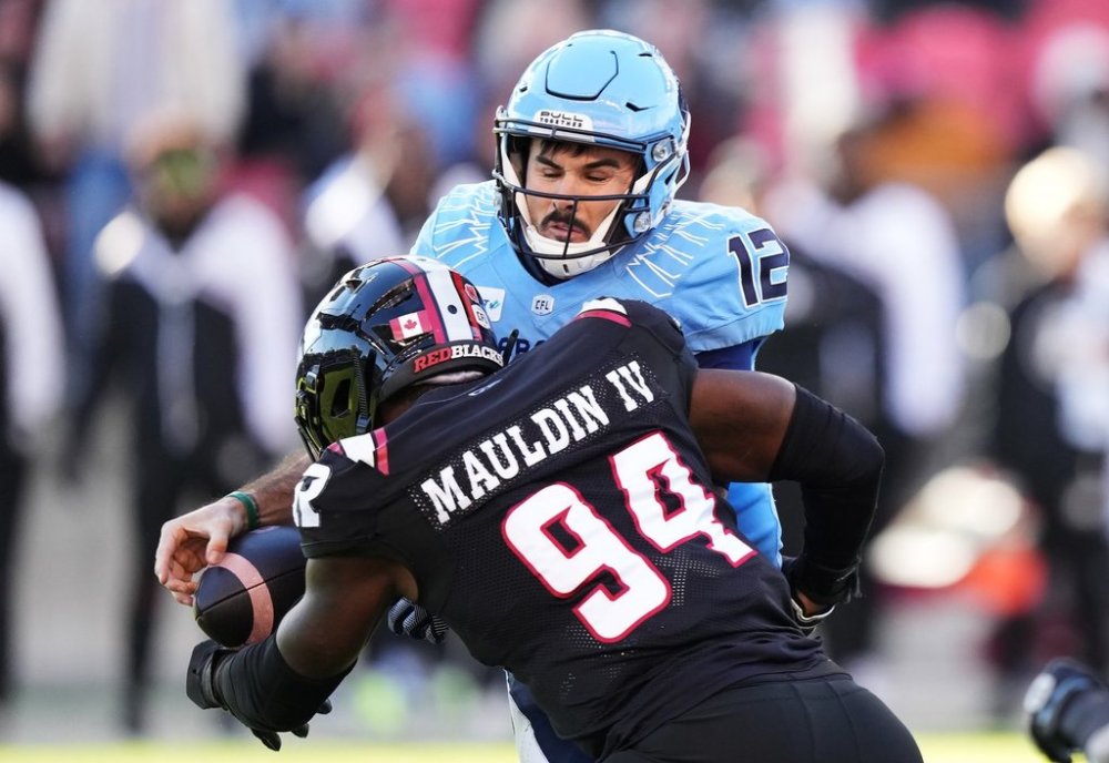 Ottawa Redblacks defensive end Lorenzo Mauldin IV (94) sacks Toronto Argonauts quarterback Chad Kelly (12) causing a fumble during first half Eastern Conference semifinal CFL football action in Toronto on Saturday, November 2, 2024. THE CANADIAN PRESS/Nathan Denette