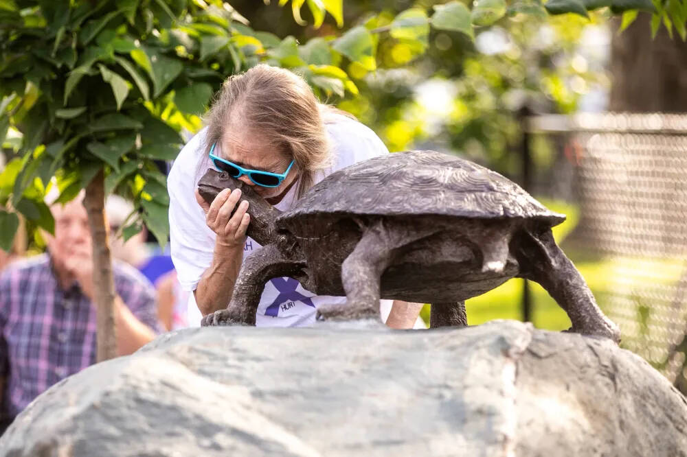 Nancy Clearwater kisses the head of the bronze turtle at the memorial unveiling ceremony at The Friends and Family Playground in Carman on Wednesday.