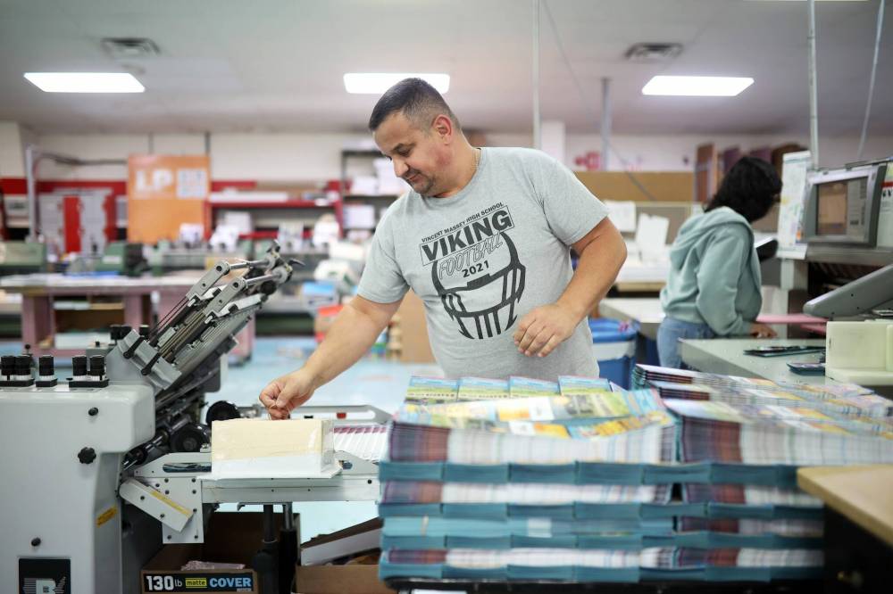 Myroslav Matsiborko with Leech Group on Braecrest Drive works on a printing order of city maps on Friday afternoon. (Tim Smith/The Brandon Sun)