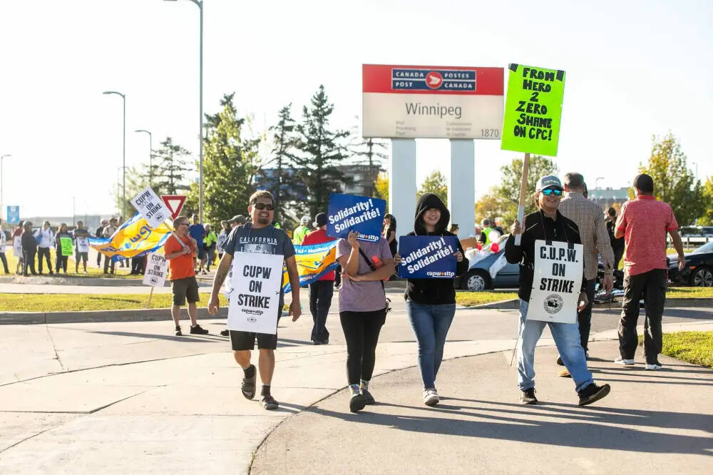 Postal workers picket at the Canada Post mail processing plant on Wellington Avenue in Winnipeg on Thursday. (Mikaela MacKenzie/Winnipeg Free Press)