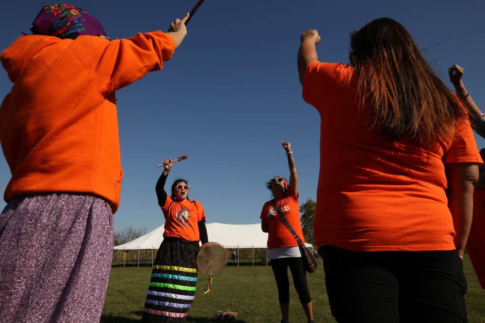 Members of the women's drum group that meets Thursday evenings at the In A Good Way Family Resource Centre perform hand drum songs as participants set up tipis on Monday. (Tim Smith/The Brandon Sun)