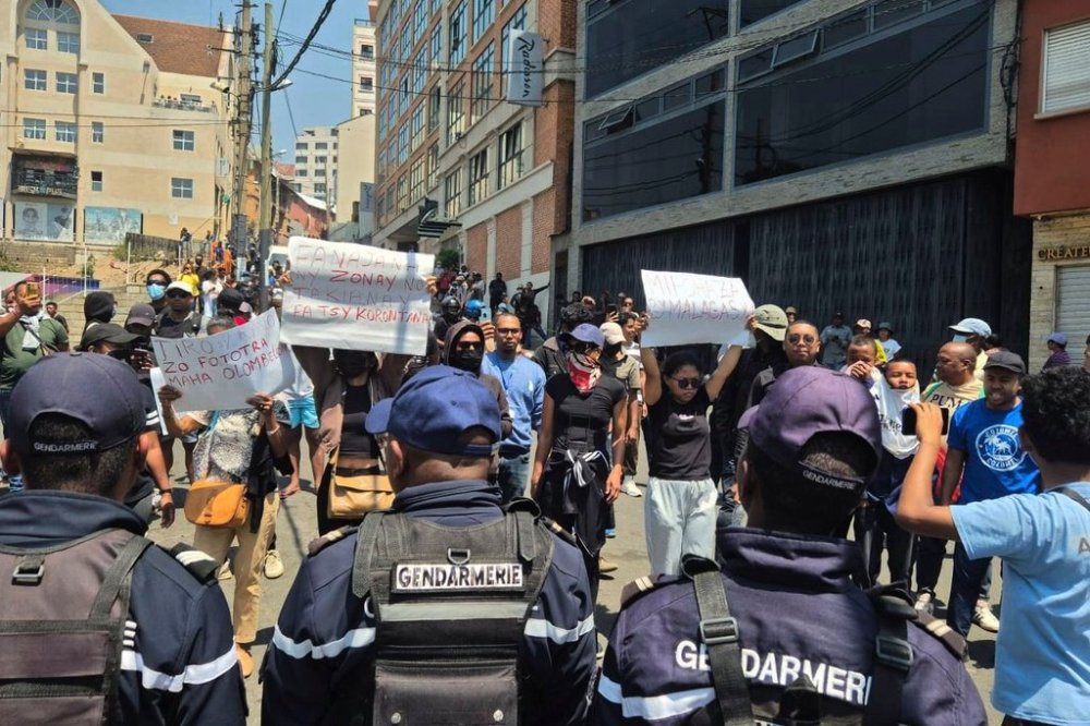 Demonstrators hold up placards reading