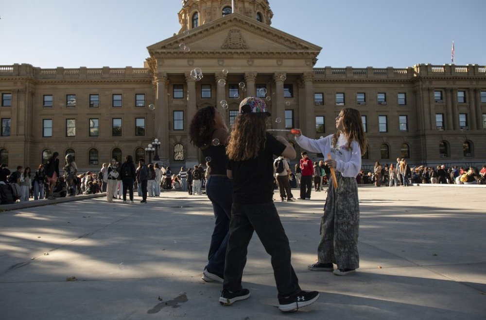 Charis Routley, 11, blows bubbles with friends as they join a student walk out and protest in support of pay for teachers and funding for schools at the Alberta legislature in Edmonton on Monday, Sept. 22, 2025. THE CANADIAN PRESS/Amber Bracken