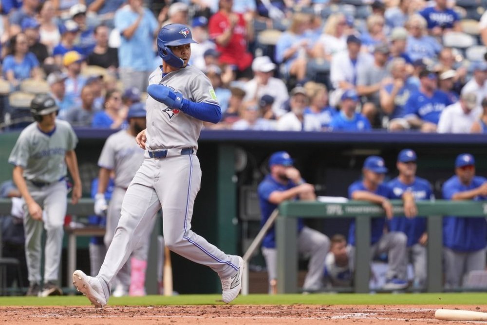 Toronto Blue Jays' Andres Gimenez runs home to score on a double by George Springer during the second inning of a baseball game against the Kansas City Royals, Sunday, Sept. 21, 2025, in Kansas City, Mo. (AP Photo/Charlie Riedel)
