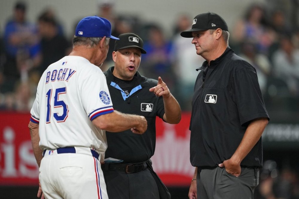 Texas Rangers manager Bruce Bochy (15) argues with home plate umpire Stu Scheurwater, left, and third base umpire John Bacon after being ejected from a baseball game during the eighth inning Saturday, Sept. 20, 2025, in Arlington, Texas. (AP Photo/Julio Cortez)