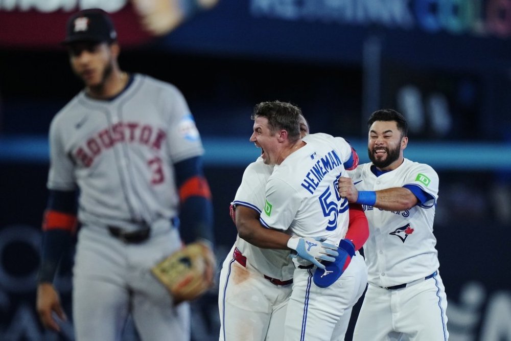Toronto Blue Jays' Tyler Heineman (55) celebrates his game-winning hit against the Houston Astros with Vladimir Guerrero Jr. (hidden) and Isiah Kiner-Falefa (right) during tenth inning MLB baseball action in Toronto on Tuesday, Sept. 9, 2025. THE CANADIAN PRESS/Nathan Denette