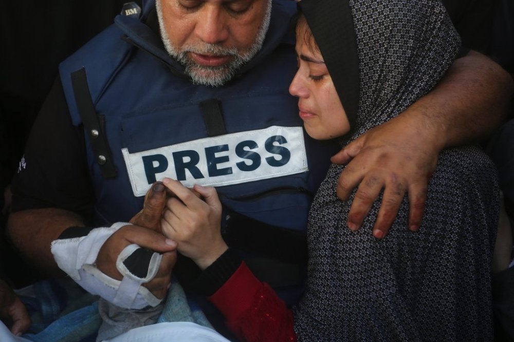 FILE - Al Jazeera journalist Wael Dahdouh holds the hand of his son, Hamza, who also worked for Al Jazeera and was killed in an Israeli airstrike, in Rafah, Gaza Strip, Jan. 7, 2024. (AP Photo/Hatem Ali, File)