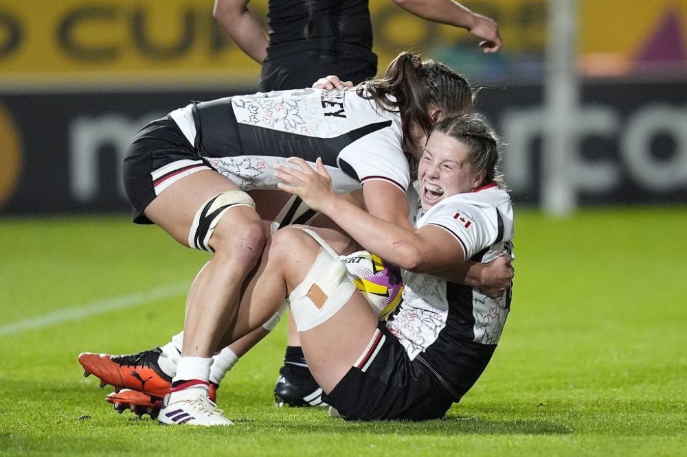 Canada's Sophie de Goede, right, celebrates with teammates after scoring a try during the Women's Rugby World Cup 2025 semifinal match between Canada and New Zealand at Ashton Gate, Bristol, England, Friday Sept. 19, 2025. (Andrew Matthews/PA via AP)