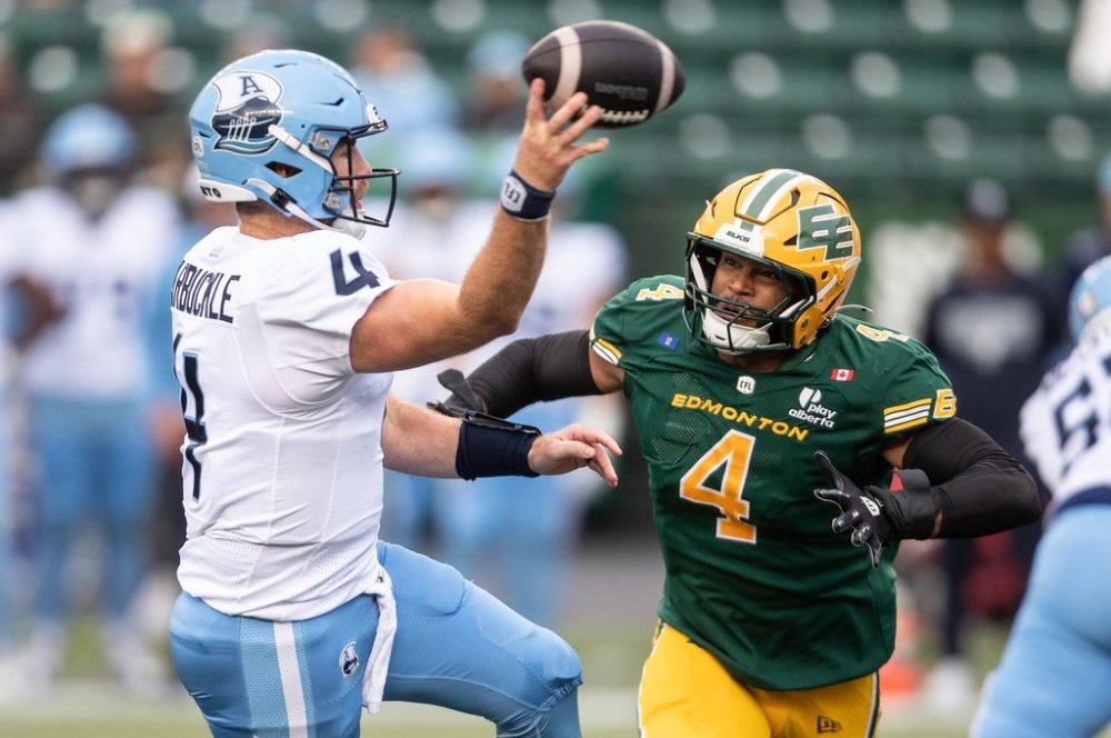 Toronto Argonauts quarterback Nick Arbuckle (4) makes the throw as Edmonton Elks' Brandon Barlow (4) chases during first half CFL action in Edmonton, on Friday Aug. 15, 2025. THE CANADIAN PRESS/Jason Franson