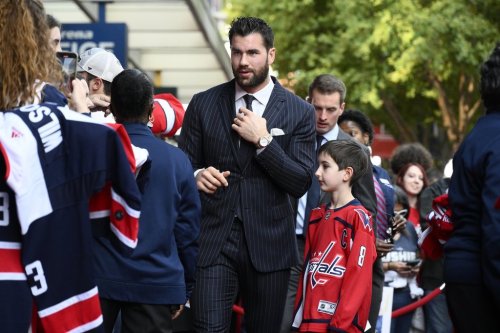 Capitals winger Tom Wilson (43) walks the red carpet and signs for fans before an NHL hockey game against New Jersey Devils in Washington on Saturday, Oct. 12, 2024. (AP Photo/Nick Wass)