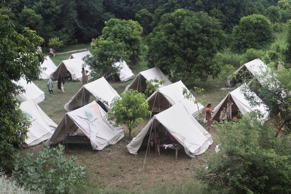 People, who fled from their homes due to flood, take shelter at a relief camp on the outskirts of Multan, Pakistan, Tuesday, Sept. 2, 2025. (AP Photo/Asim Tanveer)