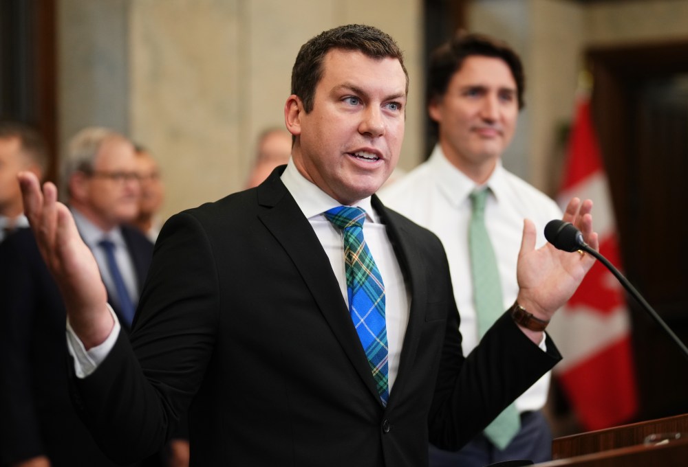Kody Blois, chair of the national Liberal rural caucus and Nova Scotia Liberal caucus, speaks during a news conference as then Prime Minister Justin Trudeau looks on in Ottawa on Oct. 26, 2023. Current PM Mark Carney is sending Blois to China with a trade mission with the goal of resolving a trade dispute that led China to impose tariffs on Canadian canola. (The Canadian Press)