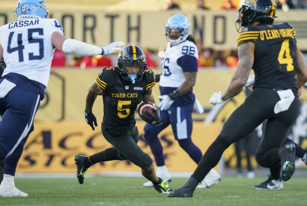 Hamilton Tiger Cats running back Greg Bell (5) runs for a gain during first half CFL pre-season football game action against the Toronto Argonauts in Hamilton, Ont. on Saturday, May 24, 2025. THE CANADIAN PRESS/Peter Power