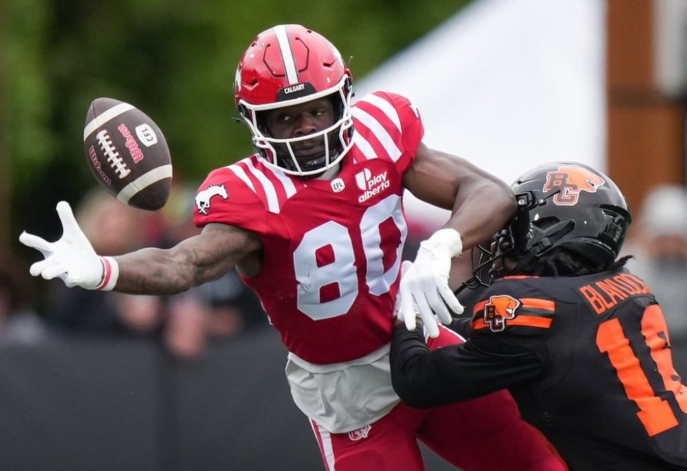 Calgary Stampeders' Damien Alford, left, reaches for the ball as B.C. Lions' Travian Blaylock defends during the second half of a pre-season CFL football game, in Langford, B.C., on Monday, May 19, 2025. THE CANADIAN PRESS/Darryl Dyck