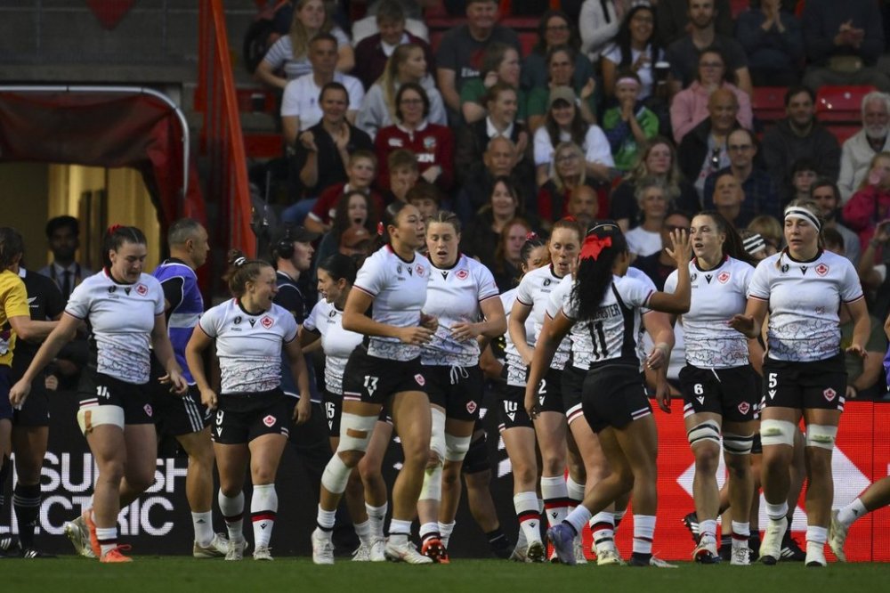 Canada's team players celebrate after scoring their first try during the Women's Rugby World Cup 2025 semifinal match between New Zealand and Canada in Bristol, England, Friday, Sept. 19, 2025. (AP Photo/Anthony Upton)